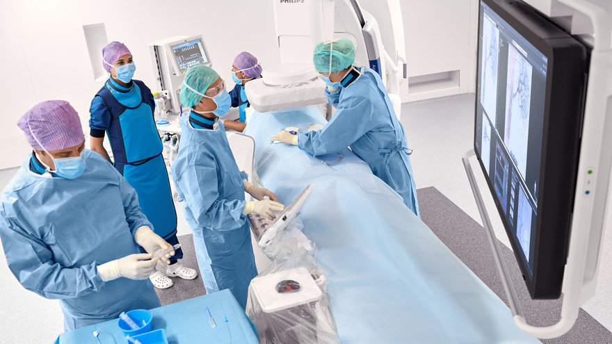 Image of patient on table in cath lab with staff working